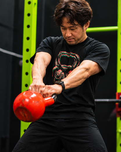Tシャツを着てケトルベルスイングをするモデル
